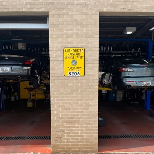 image of certified Maryland State Inspection sign with license number on it posted on outside of Columbia Auto Care in Columbia Md. shop bays