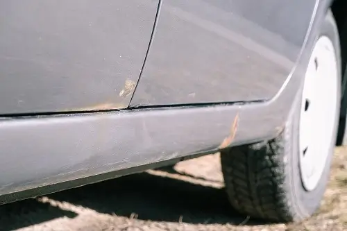 3 Reasons It’s Not OK to Never Wash Your Car? | Columbia Auto Care & Car Wash in Columbia, MD. Closeup image of a silver car door with dirt and rust.