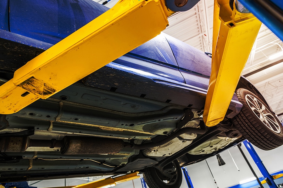 Close up of a blue car being lifted for doing a regular inspection | Columbia Auto Care in Columbia, MD