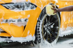 Cleaning of modern rims of luxury yellow car by a professional | Columbia Auto Care